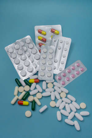 Many different pills, medicines and capsules on blue background. Selective focus. Concept for...