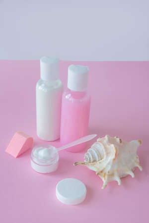 White and pink cosmetic bottles on rose background. Blank label for brand mockup. Concept of natural organic cosmetics, skin care.の写真素材