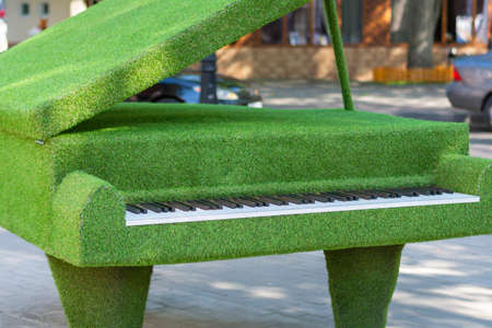 Piano made of artificial green grass, garden topiary. Selective focus, shallow depth of field.の写真素材