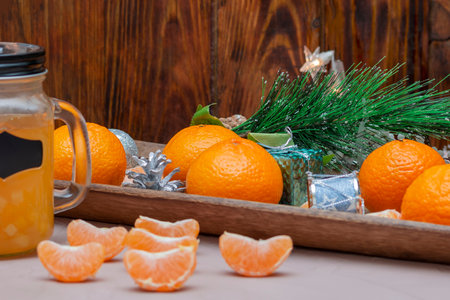 Tangerines on wooden background and jar with handle for fresh. Christmas composition, selective focus.の写真素材