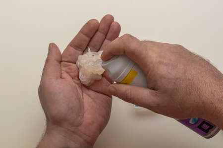 Man's hands squeeze foam or shaving gel out of bottle. Male lotion for facial skin care. Close-up,...