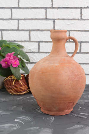 Vintage clay jug in home interior. Handmade brown old vessel.の写真素材