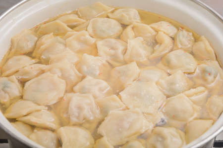Homemade dumplings are cooked in saucepan with boiling broth. Close-up. selective focus.の写真素材
