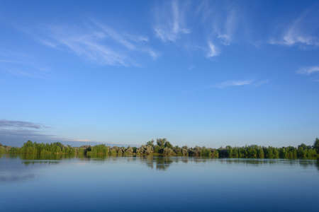 Sky with feather clouds in morning over river in summer. Beautiful landscape, kind of fog.の写真素材