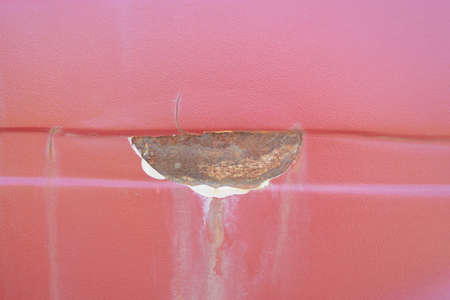 Peeling paint on the car body. Rust under putty. Concept of improper car painting.の写真素材
