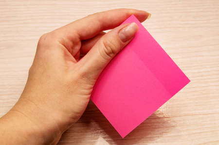 Left female hand holds pink notes for memos