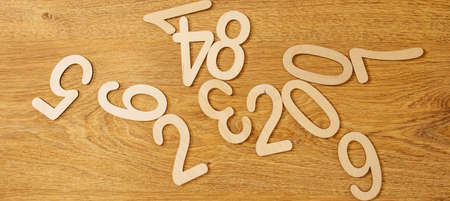 Flatley, top view on wooden numbers from zero to nine scattered randomly on wooden background