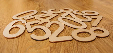 Flatley, side view on wooden numbers from zero to nine scattered randomly on wooden background