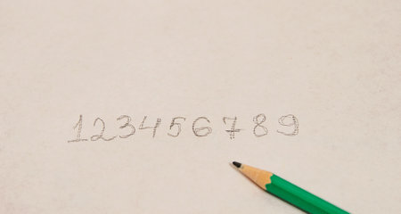 Written numbers in order from zero to nine in pencil lying side by side on a white background