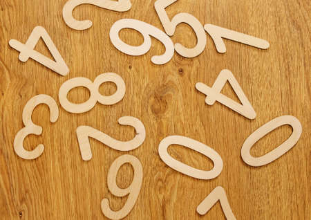 Flatley, top view on wooden numbers from zero to nine scattered randomly on wooden background