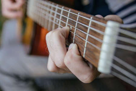 close-up of a guitar playing with a man's hand playing the strings