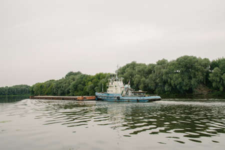 08/21/2021 Russia, Kolomna. An old rusty barge sails by on the Moscow River in summerのeditorial素材