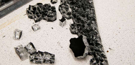 Glass debris and debris from the explosion of the glass panel of the stove scattered on the kitchen...