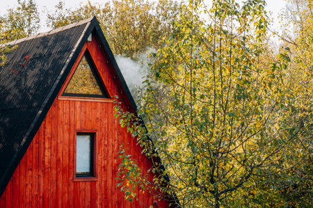 Autumn landscape of a red house near trees on a sunny day