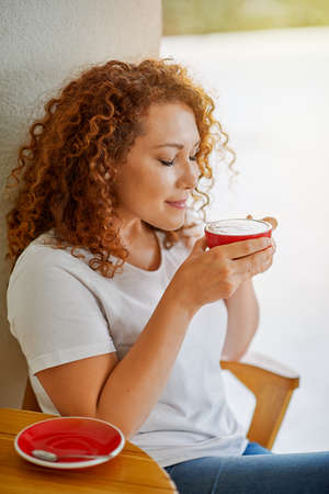 A young woman drinks coffeeの写真素材