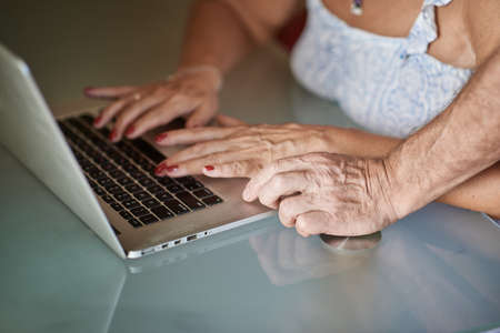 Close-up of the hands of an adult man and a woman on the laptop