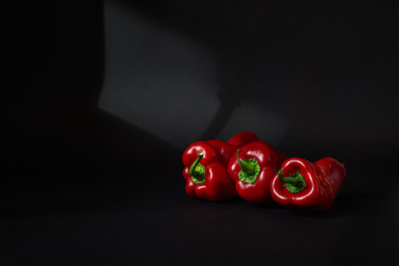 Three red paprika on the black backgroundの写真素材