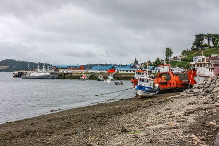 Chiloe Island, Chile - February 17, 2012: Fishing boats during low tide in Chiloe island, Chile.のeditorial素材