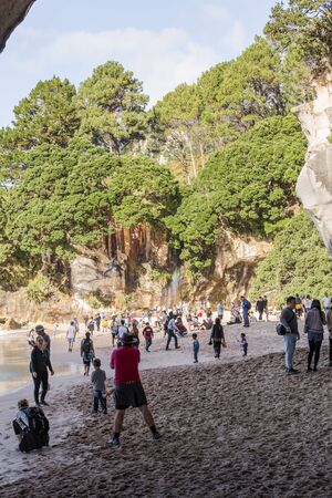 Coromandel, New Zealand - June 04, 2017: Busy day at Cathedral Cove in Coromandel Peninsula on the North Island of New Zealand. Tourists exploring around it.のeditorial素材
