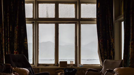 Cozy room and rain outside the big window.
