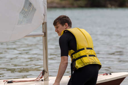 Young man on the sailing boatの写真素材