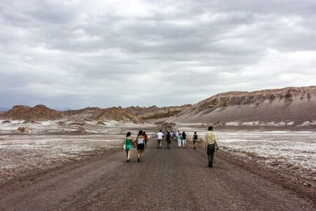 Atacama Desert, Chile - January 18, 2013:  A tour group wanders down a road through Valley Moon,...