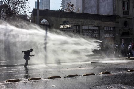 Santiago, Chile - July 14, 2011: Police use water cannons against protestors during a protest in Santiago, Chileのeditorial素材