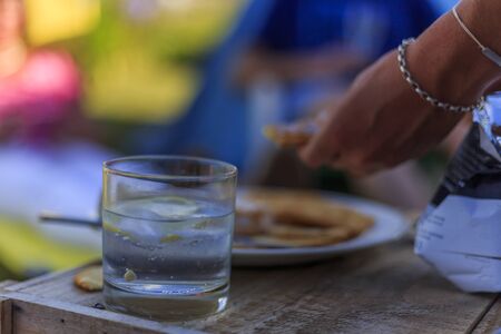 Gin and tonic on the table, hands reaching for food on a party tableの写真素材