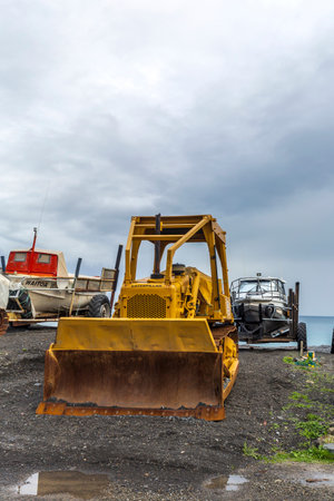 Ngawi Harbour, New Zealand - May 30, 2021: Local beached fishing fleet launched to sea by old rusty bulldozers.のeditorial素材