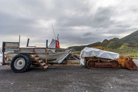 Ngawi Harbour, New Zealand - May 30, 2021: Local beached fishing fleet launched to sea by old rusty bulldozers.のeditorial素材