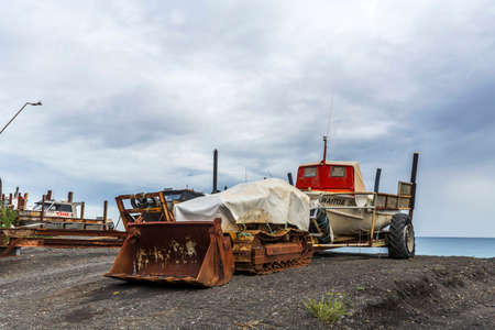 Ngawi Harbour, New Zealand - May 30, 2021: Local beached fishing fleet launched to sea by old rusty bulldozers.のeditorial素材