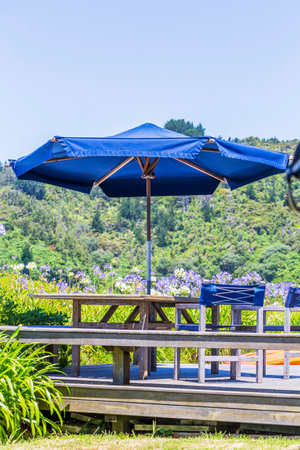 Beachy backyard: Garden furniture and parasol overlooking the oceanの写真素材