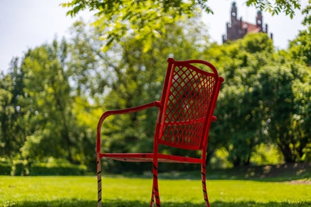 Vibrant Red Chair in Tranquil Park Settingの写真素材
