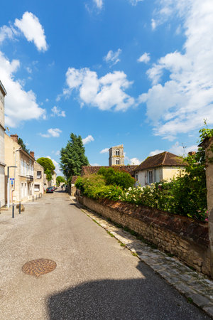 Chateau-Landon, France - May 22, 2024: Quaint Street View with Historic Church Tower in Chateau Landonのeditorial素材