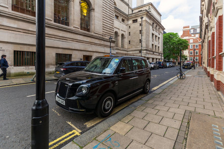 London, UK - May 15, 2024: Classic London Black Taxi on Historic Streetのeditorial素材