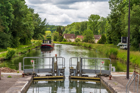 Saint-Pierre-les-Nemours, France - May 21, 2024: Boat Moored on Tranquil Canal Beyond Lock Gates in...