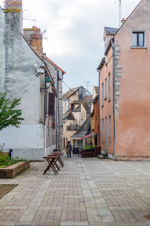 Montargis, France - May 24, 2024: A charming street in Montargis, France, lined with rustic buildings and outdoor tablesのeditorial素材