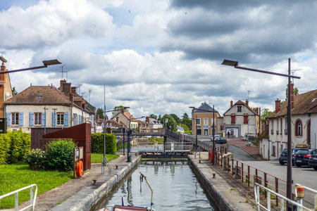 Cepoy, France - May 26, 2024: A charming view of the canal lock and village street in Cepoy, France, showcasing the quaint and picturesque essence of French small-town lifeのeditorial素材