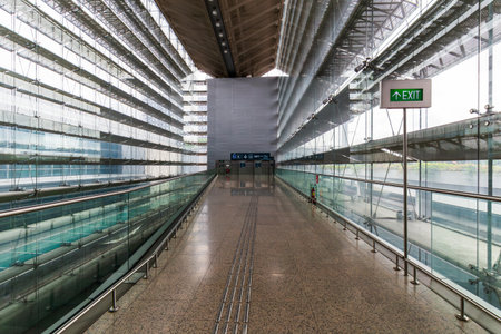 Singapore - May 31, 2024: A futuristic glass walkway in a Singapore airport terminal, showcasing...