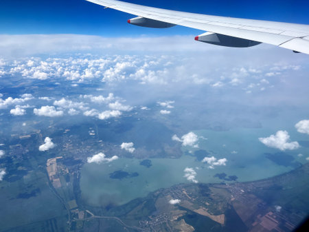 Aerial View of Landscape with Clouds and Plane Wingの写真素材