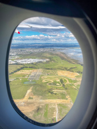 Aerial View Through Airplane Window Over Suburbs and Coastlineの写真素材