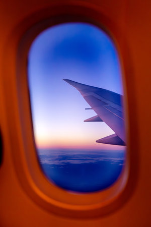 Airplane Wing Framed by Window at Twilightの写真素材