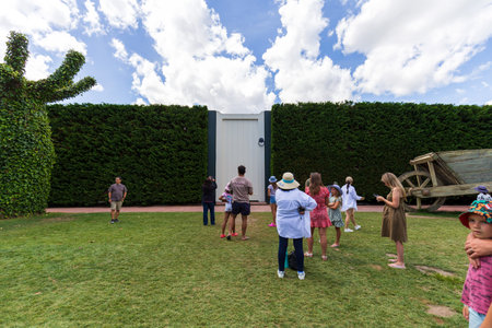 Hamilton, New Zealand - January 04, 2024: A group of visitors gathers around a giant door and cart in the Surrealist Garden at Hamilton Gardens, New Zealandのeditorial素材