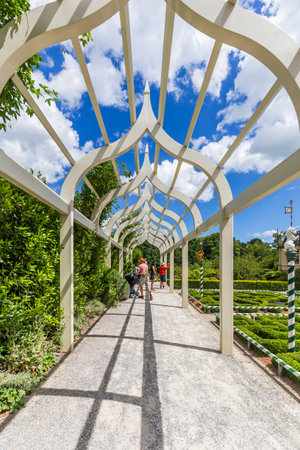 Hamilton, New Zealand - January 04, 2024: A beautifully designed walkway with ornate arching beams, casting intricate shadows over a picturesque garden scene in the Tudor Garden at Hamilton Gardens, New Zealandのeditorial素材