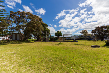 Whangamata, New Zealand - January 01, 2024: "A sunny playground and picnic area in Whangamata, New Zealand, surrounded by lush greenery, offers a perfect spot for families to gather, play, and enjoy the outdoorsの写真素材