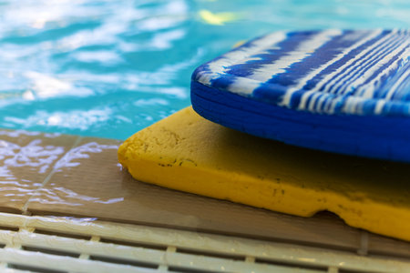 Swimming Pool with Stacked Blue and Yellow Kickboardsの写真素材