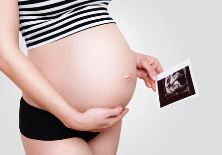 Pregnant woman holding ultrasound imageの写真素材