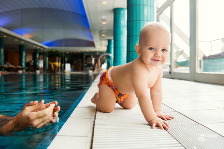 Portrait of a smiling charming 11 months child in the classroom in a swimming pool