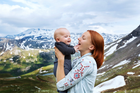 Baby and mother with the Alps mountains in nature in the Backgroundの写真素材