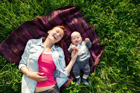 Baby and mother on nature in the parkの写真素材